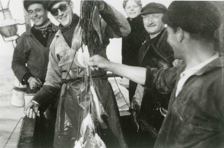 Cueillage des cordes en mer. De gauche à droite : Paul Clerc, Florent Clerc (tenant une poignée de lignes), un jeune touriste embarqué, Jean-Baptiste Macquet, Henri Clerc