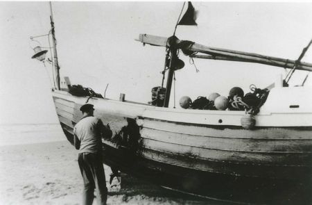 Le "Marie-Denise". Paul Clerc coaltarant son bateau afin d'en assurer l'étanchéité.